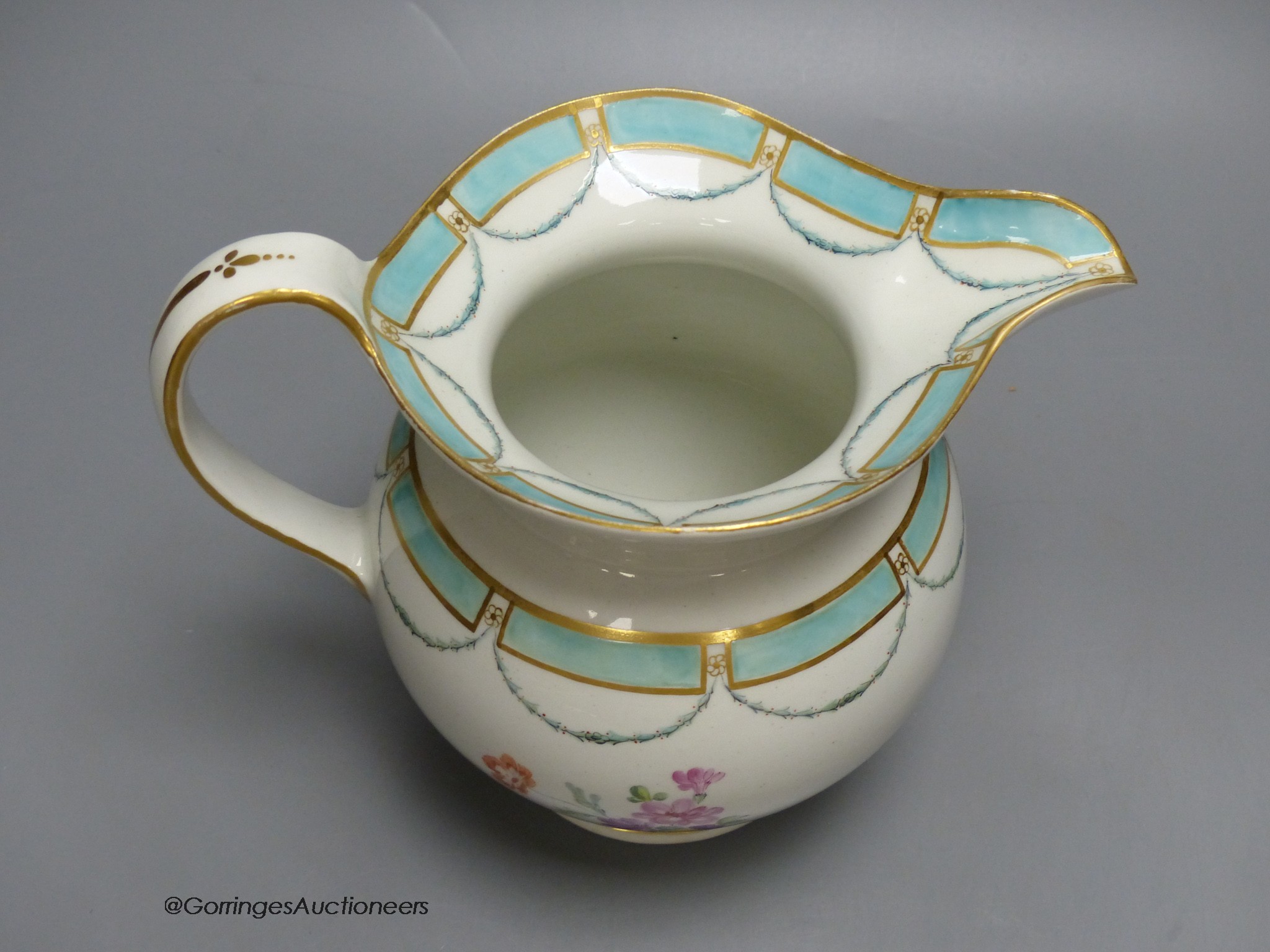 A Chelsea Derby jug of most unusual shape painted with flowers and a turquoise border, 18cm high